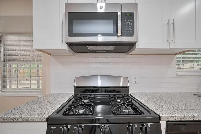 a kitchen with granite countertop stainless steel appliances stove and cabinets