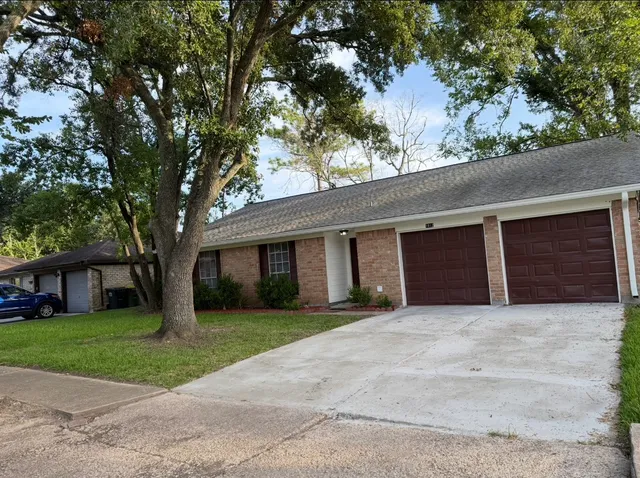 a front view of house with yard and trees all around