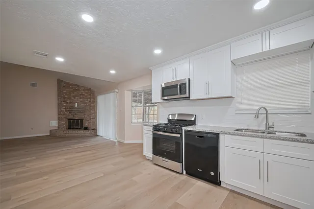 a kitchen with stainless steel appliances kitchen island granite countertop a stove sink and cabinets