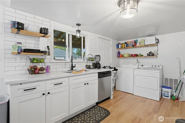 a kitchen with a refrigerator sink and white cabinets