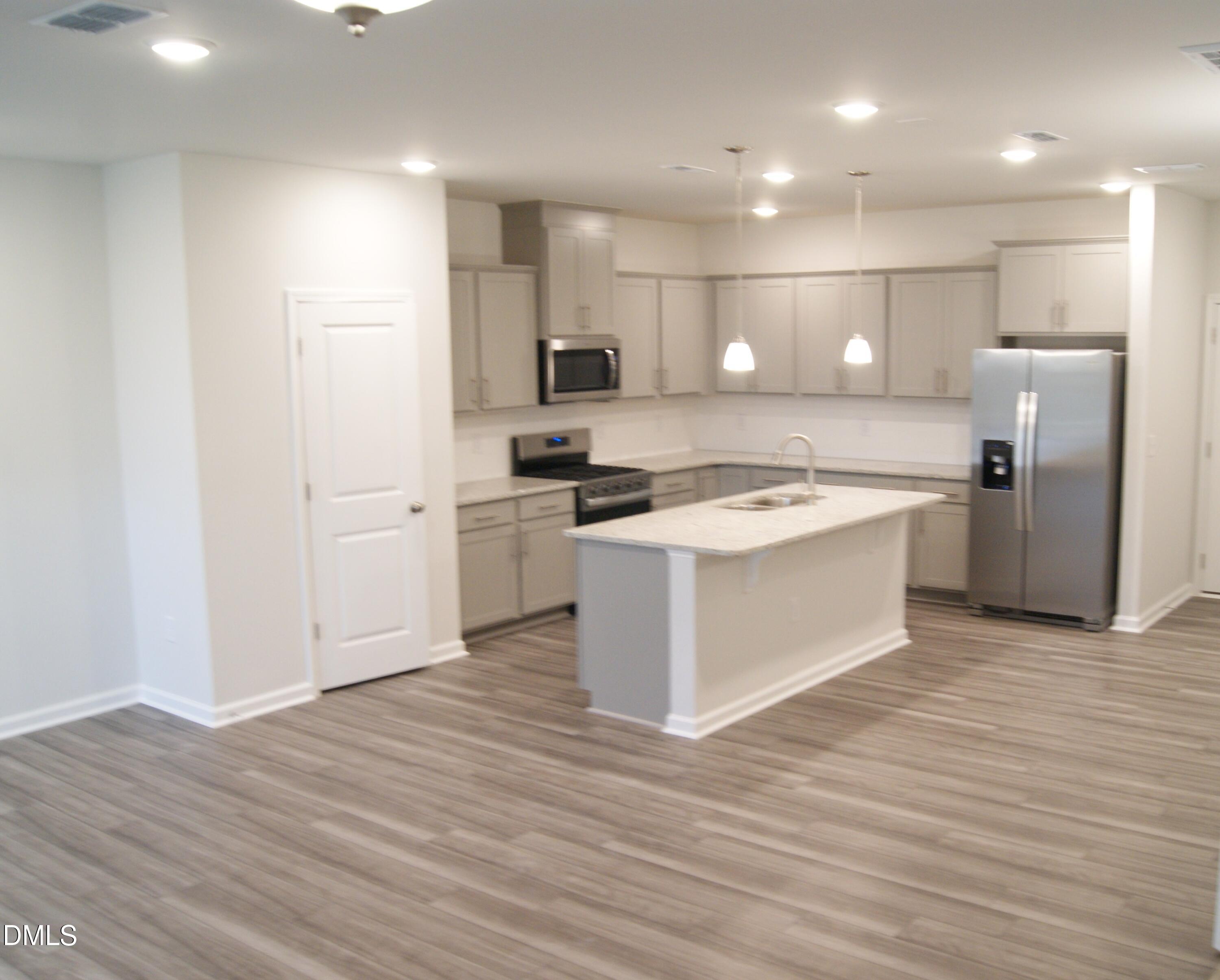 295 Glenmore Gardens Road Raleigh, NC 27603 - Photo 4 of 30 a kitchen with stainless steel appliances granite countertop a sink and refrigerator