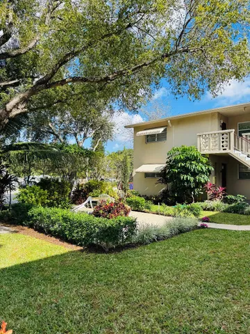 a view of house with garden and tall trees