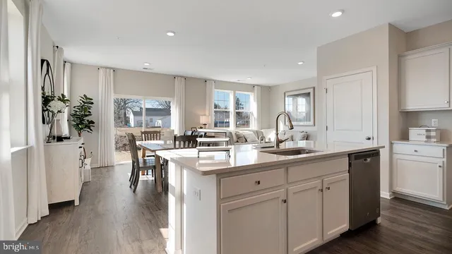 a kitchen with white cabinets and sink