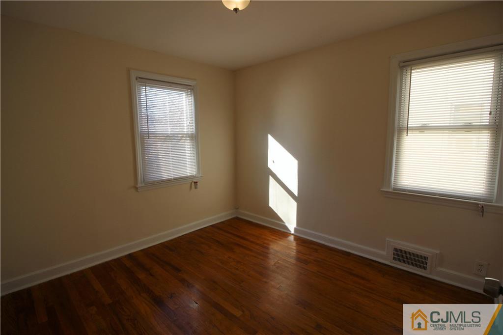 9 MacArthur Drive Edison, NJ 08837 - Photo 11 of 24 a view of an empty room with wooden floor and a window