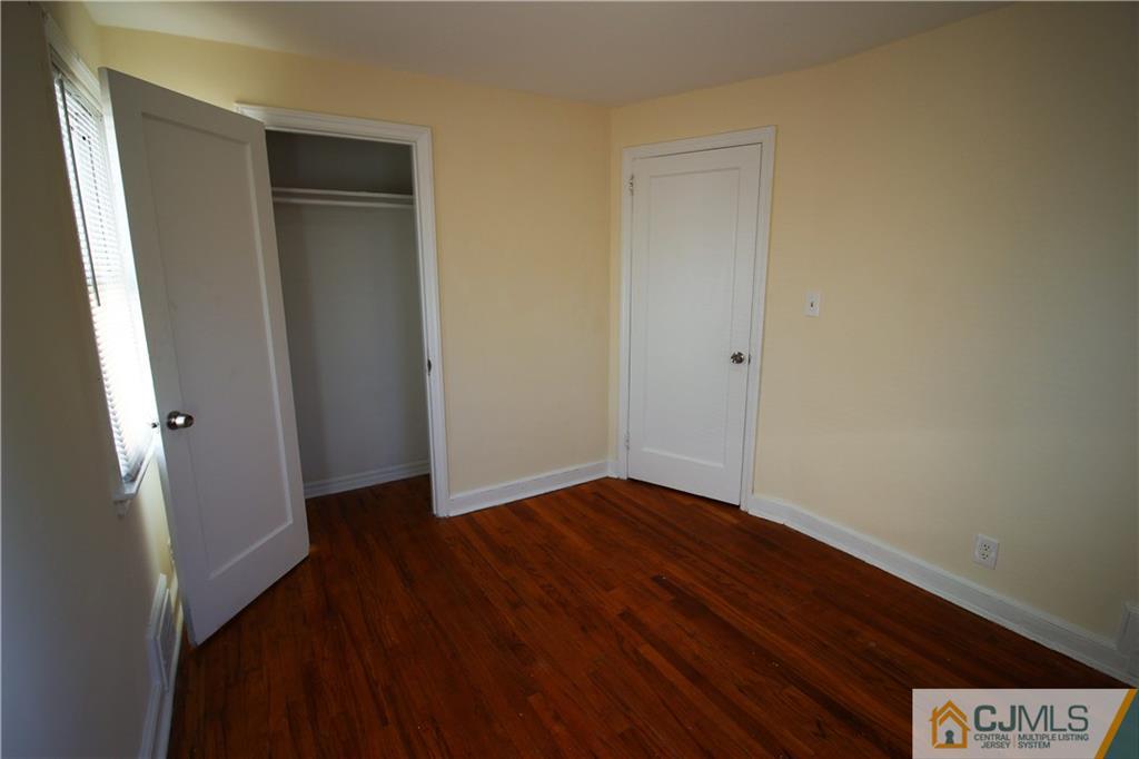 9 MacArthur Drive Edison, NJ 08837 - Photo 12 of 24 a view of an empty room with wooden floor and a window