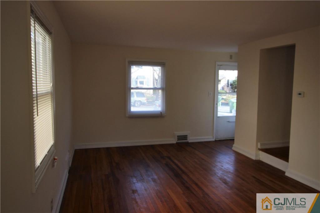 9 MacArthur Drive Edison, NJ 08837 - Photo 3 of 24 a view of an empty room with wooden floor and a window