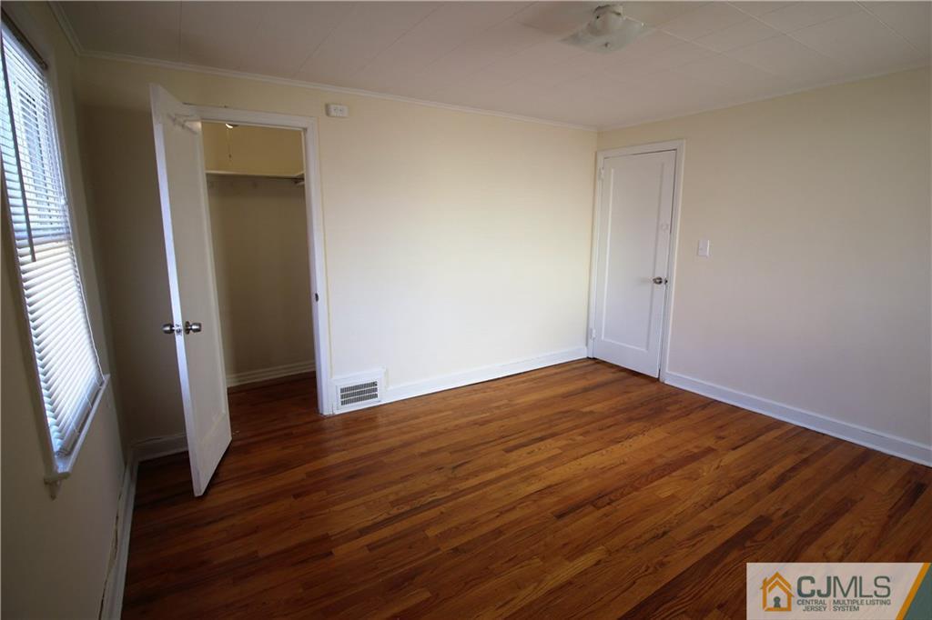 9 MacArthur Drive Edison, NJ 08837 - Photo 7 of 24 an empty room with wooden floor and entrance