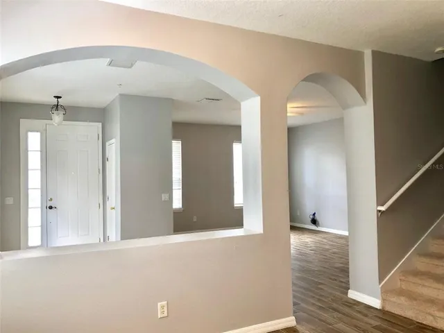 a view of a hallway with wooden floor and staircase