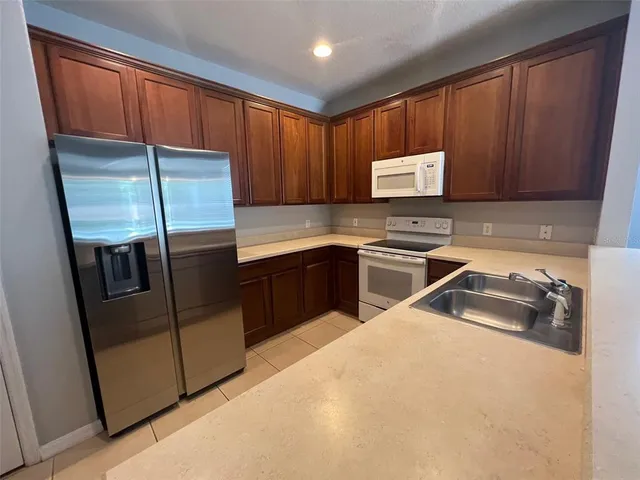 a kitchen with stainless steel appliances granite countertop a sink refrigerator and microwave