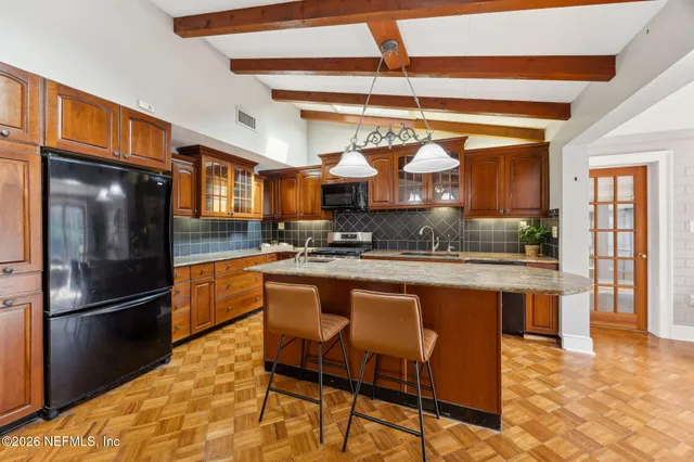 a kitchen with stainless steel appliances granite countertop a refrigerator a stove and a sink