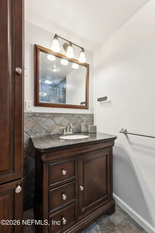 a bathroom with a granite countertop sink and mirror