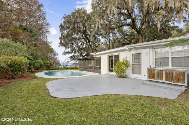 a view of a house with backyard and sitting area