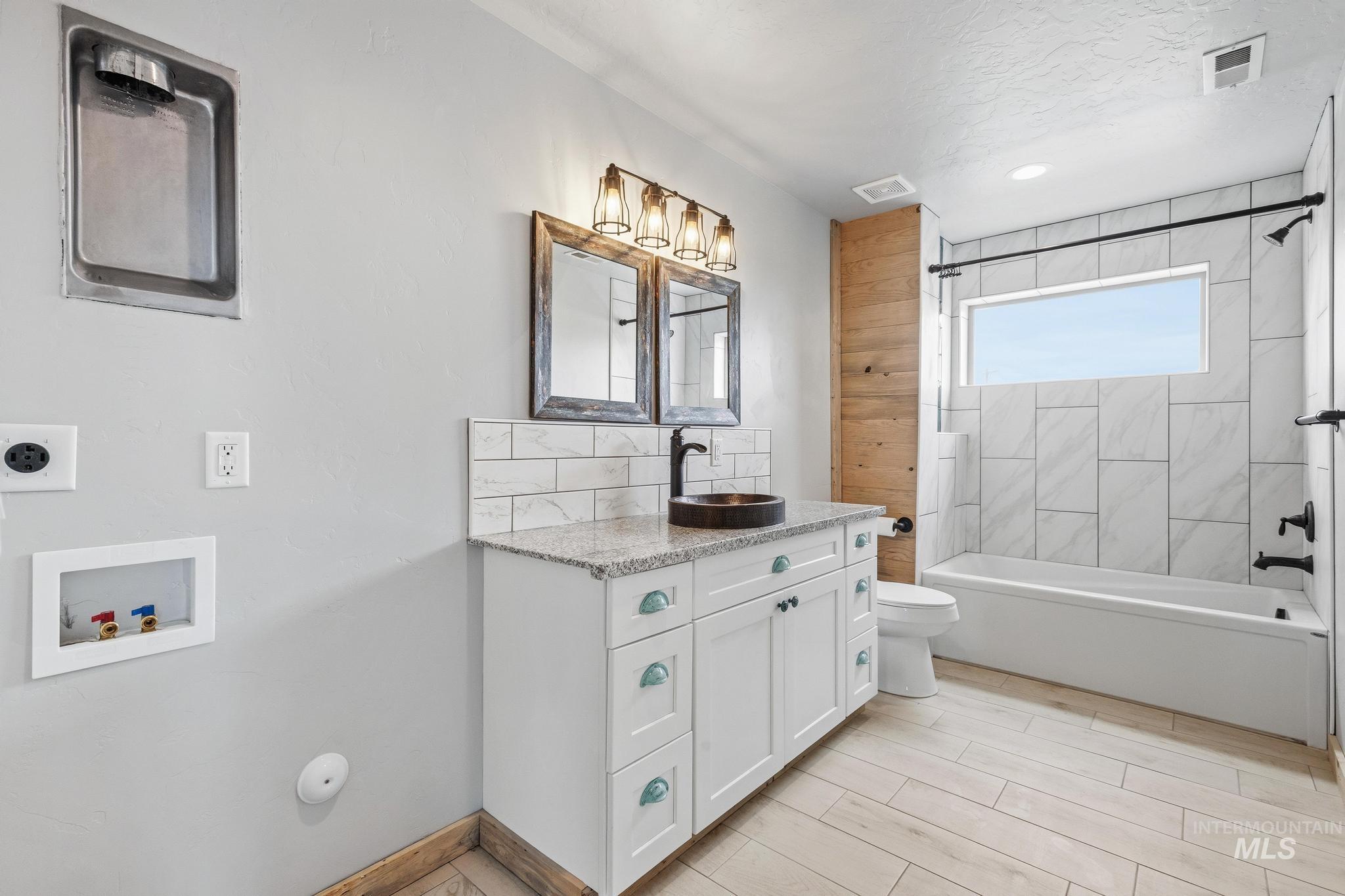 870 Desert Wind Road Boise, ID 83716 - Photo 37 of 50 Bright room featuring two windows, a wood-finish ceiling fan with integrated lighting, light gray carpeting, and rustic wood base trim