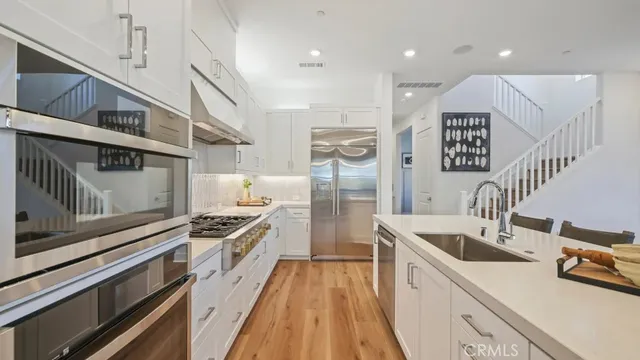 a kitchen with kitchen island a counter top space a sink stainless steel appliances and cabinets