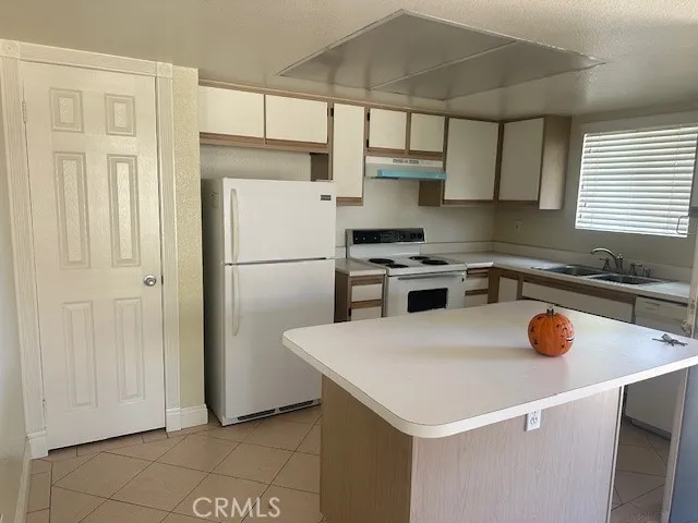 a kitchen with a refrigerator a stove a sink and cabinets