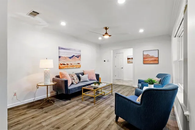 a living room with furniture and wooden floor