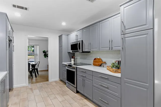 a kitchen with stainless steel appliances granite countertop a refrigerator and a stove
