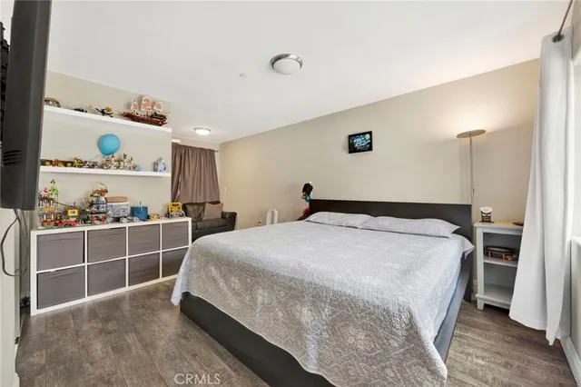a large bedroom with a bed and a flat screen tv