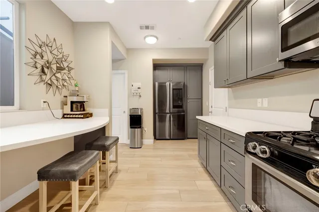 a large white kitchen with a sink dishwasher a stove and a refrigerator with wooden floor