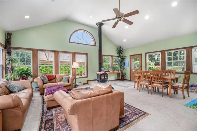 a living room with furniture ceiling fan and a large window