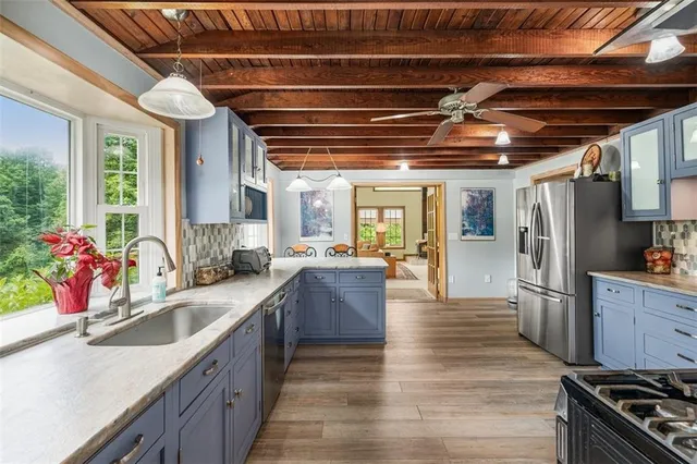a kitchen with stainless steel appliances granite countertop a stove cabinets and wooden floor