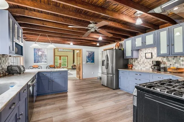 a kitchen with granite countertop a wooden cabinets and a large window