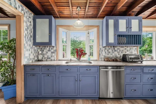 a kitchen with stainless steel appliances granite countertop a wooden cabinets and a stove top oven