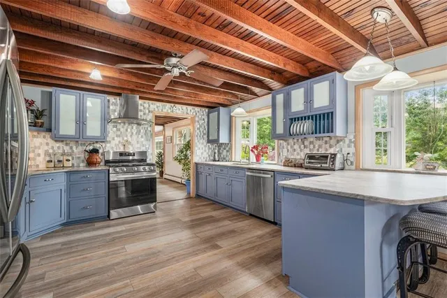 a kitchen with stainless steel appliances granite countertop a refrigerator oven a sink dishwasher and wooden cabinets with wooden floor