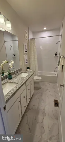 a bathroom with a granite countertop sink mirror vanity and bathtub
