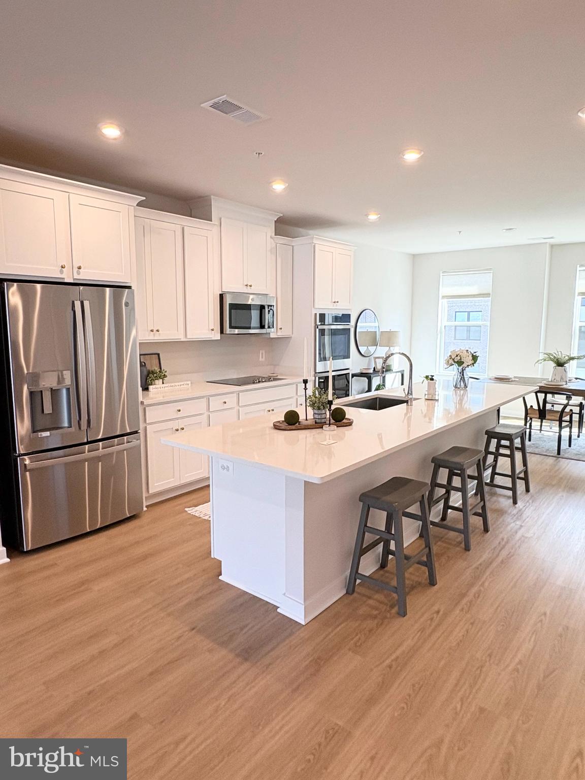14114 Gypsum Loop, Unit 64 Chantilly, VA 20151 - Photo 3 of 40 a kitchen with stainless steel appliances a refrigerator a stove a sink a dining table and chairs