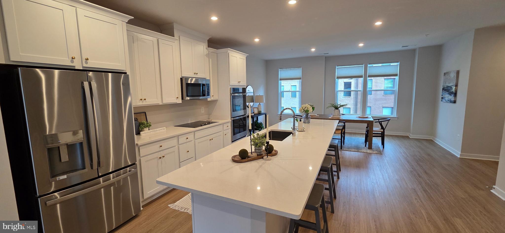 14114 Gypsum Loop, Unit 64 Chantilly, VA 20151 - Photo 4 of 40 a kitchen with stainless steel appliances a refrigerator a stove a dining table and chairs with wooden floor