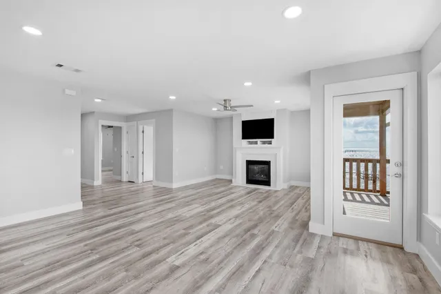 a view of a livingroom with a fireplace wooden floor and window