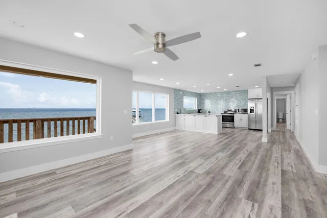 a view of empty room with wooden floor and window