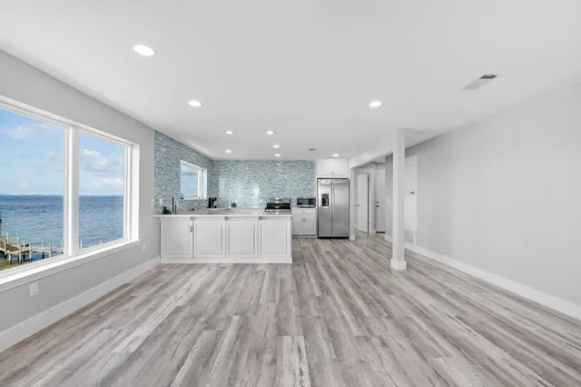 a large kitchen with stainless steel appliances granite countertop a large center island and a stove in it