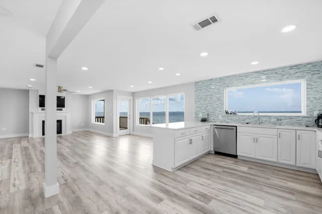 a kitchen with granite countertop white cabinets and white appliances