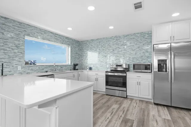 a kitchen with stainless steel appliances a refrigerator sink and stove