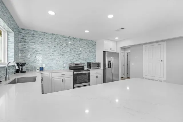 a living room with large window and a fireplace