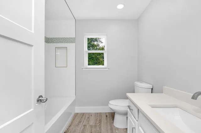 a bathroom with a sink a toilet and a window