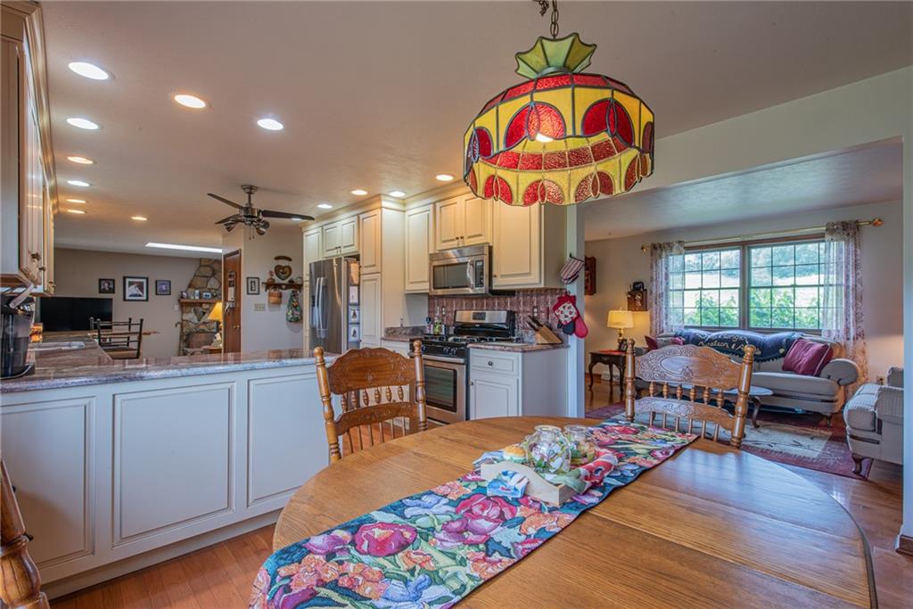 1453 Airport Road Vandergrift, PA 15690 - Photo 12 of 48 a very nice looking open kitchen with stainless steel appliances kitchen island granite countertop a dining table and chairs with wooden floor