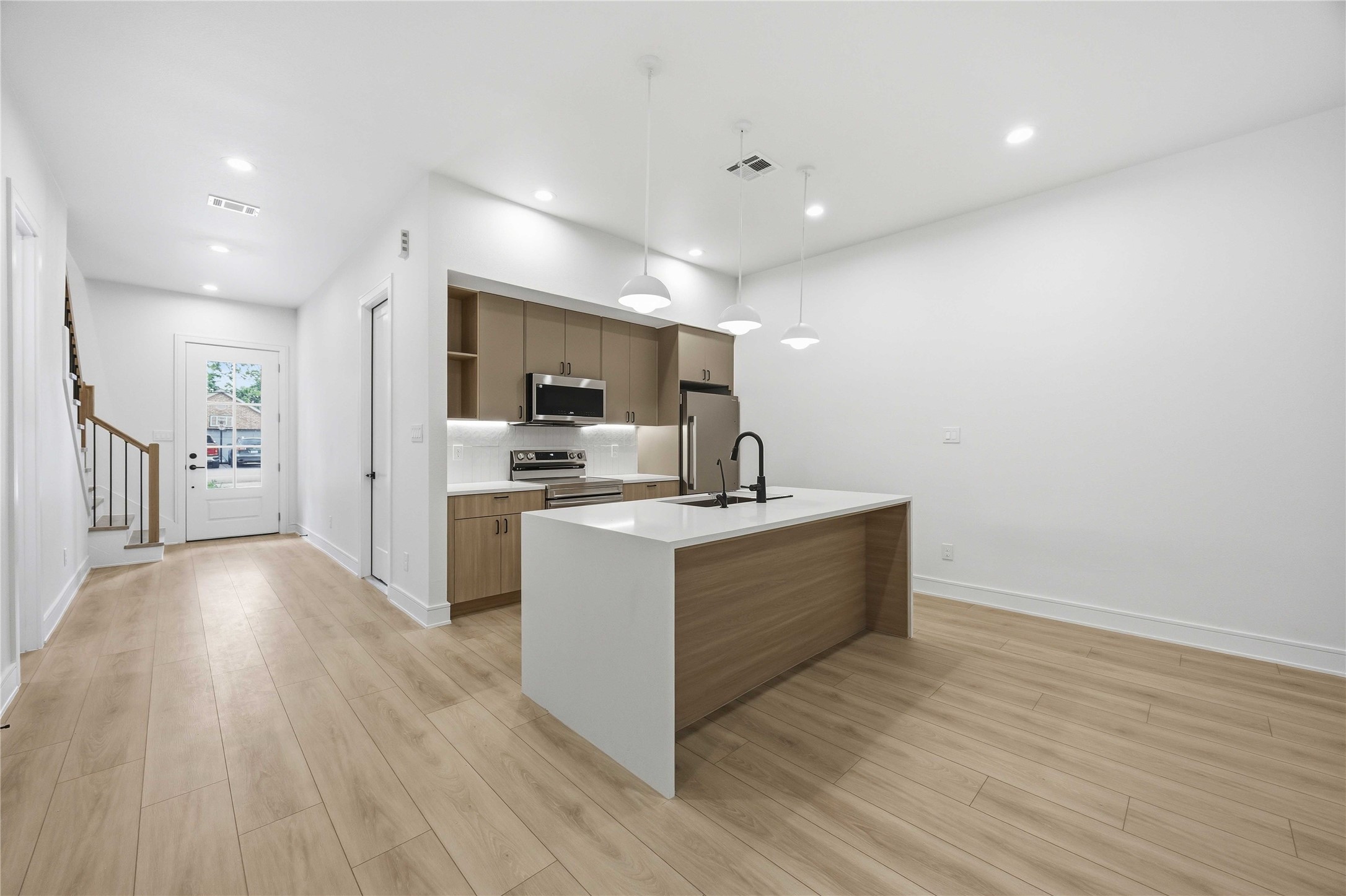 8019 Grandview Street, Unit B Houston, TX 77051 - Photo 6 of 30 a large white kitchen with wooden floor