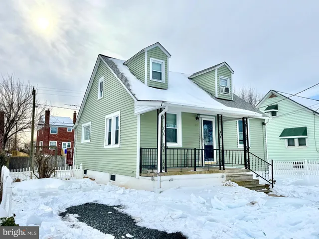 a view of a white house with large windows and a small yard