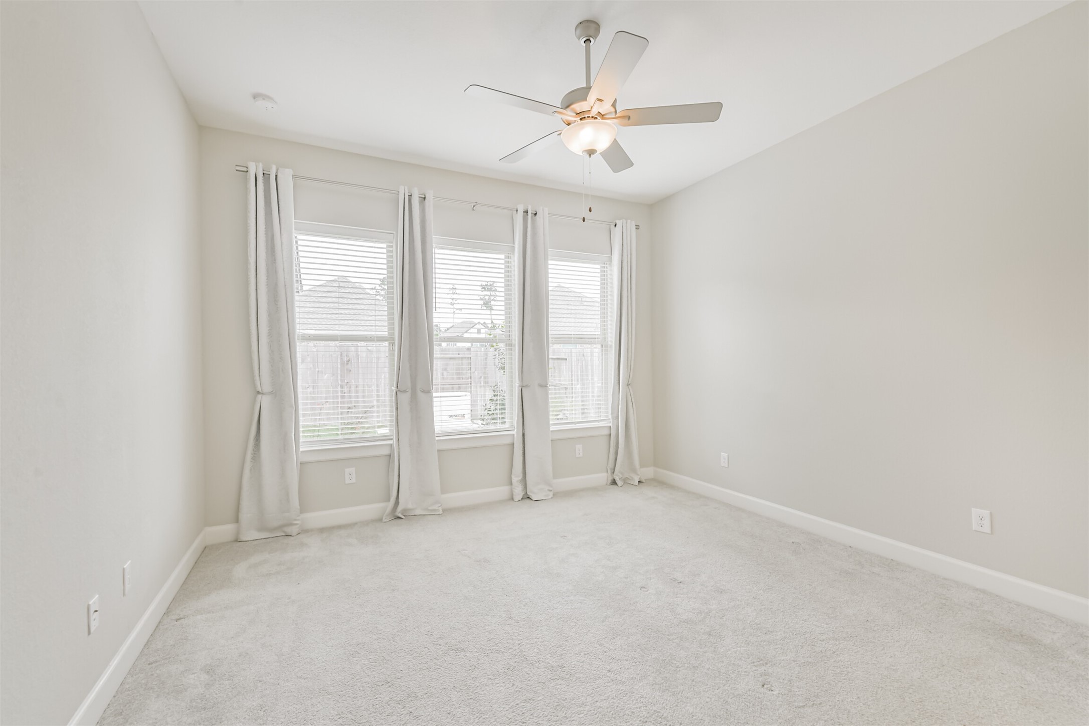 15611 Rising Wren Court Conroe, TX 77302 - Photo 26 of 38 an empty room with windows and chandelier fan