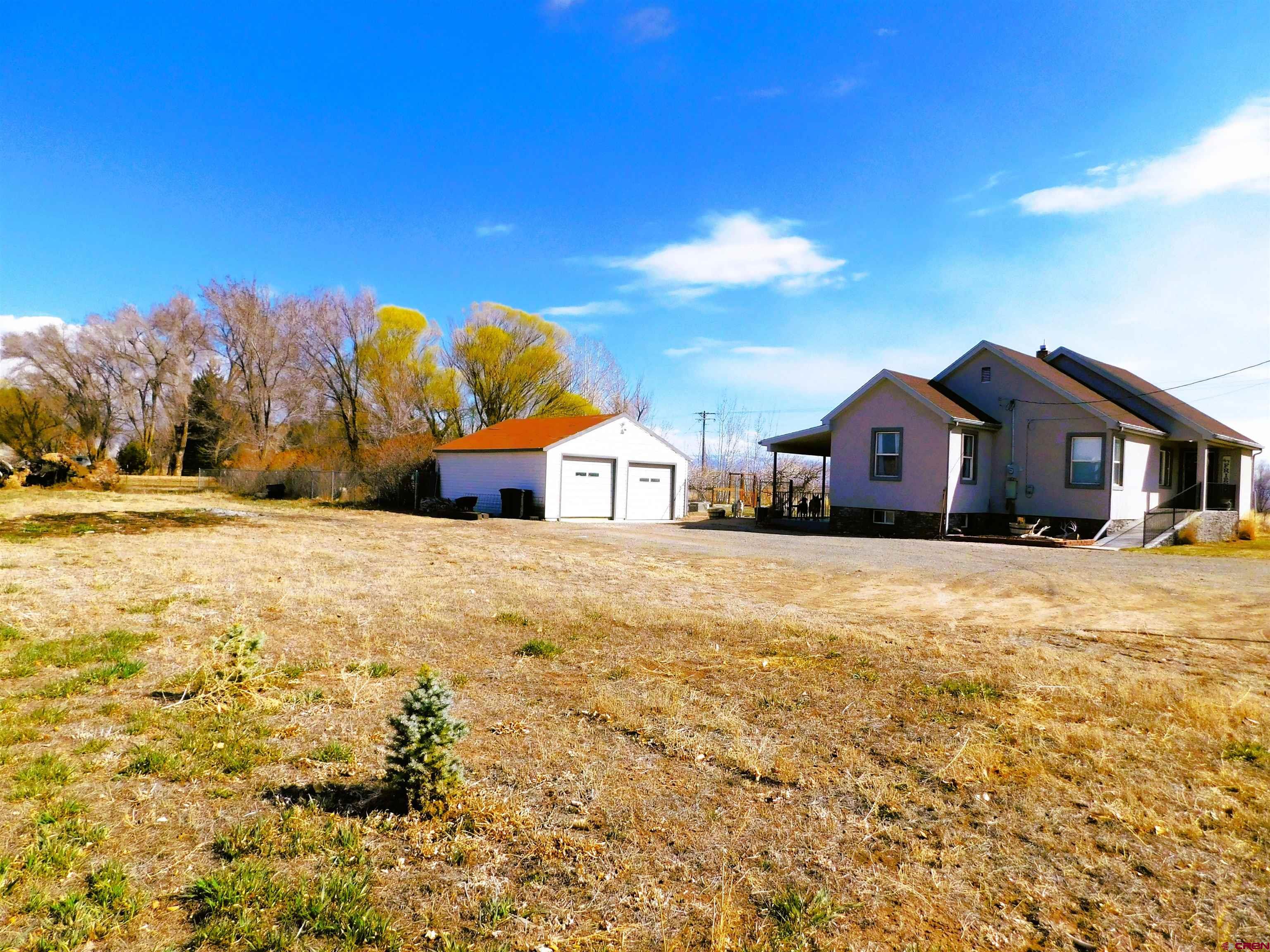 14977 F Road Delta, CO 81416 - Photo 31 of 45 a front view of house with yard and trees in the background