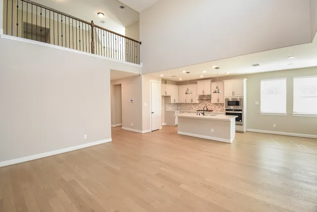 a kitchen with a sink chandelier and wooden floor
