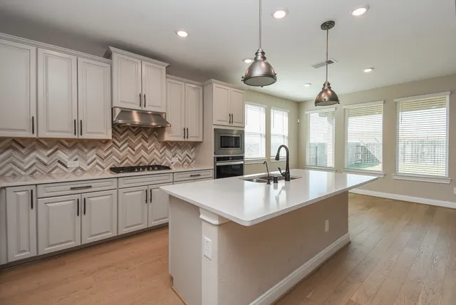 a view of a stove top oven sitting inside of a kitchen