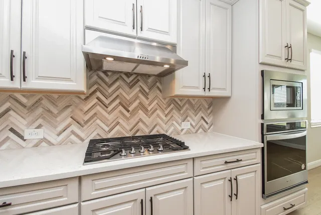 an empty room with a chandelier fan and windows