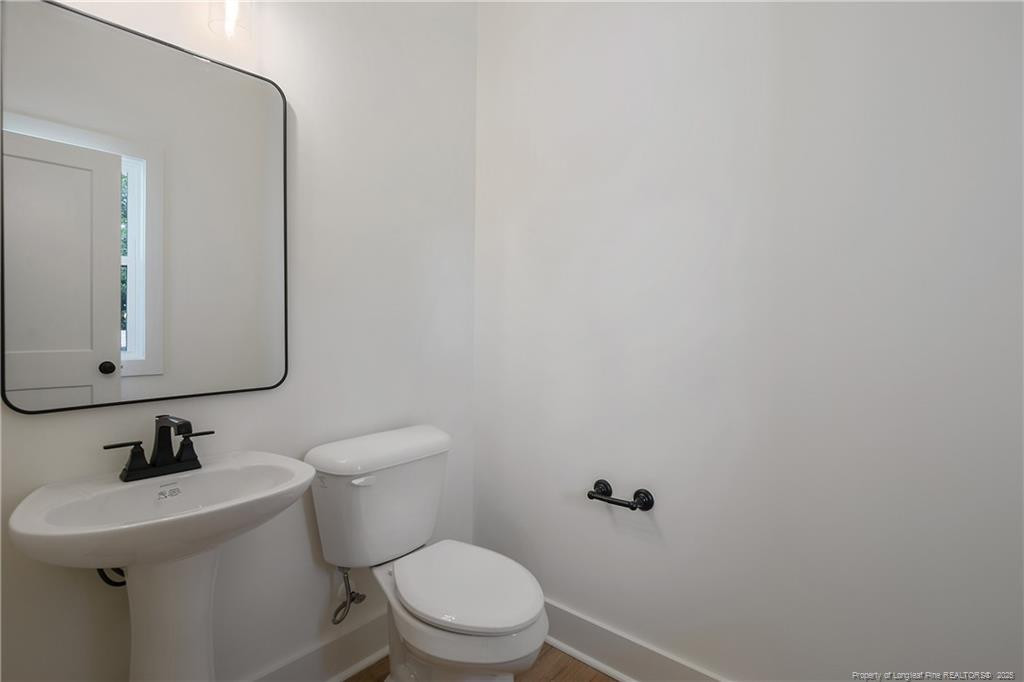 4728 Butler Nursery Road Fayetteville, NC 28306 - Photo 7 of 49 a bathroom with a toilet a sink and mirror