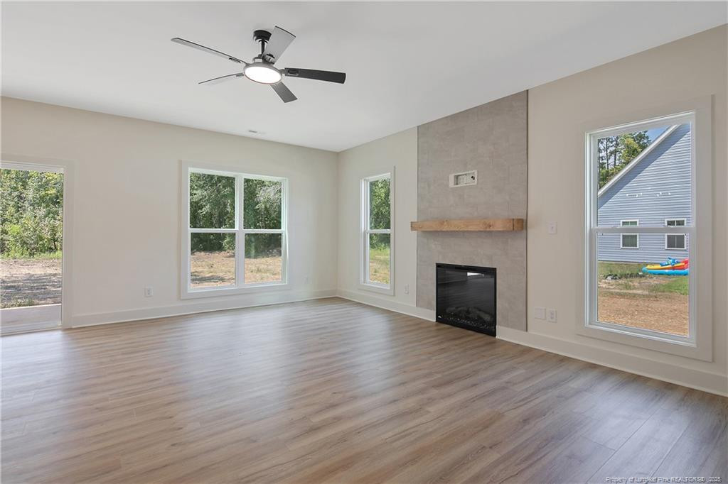 4728 Butler Nursery Road Fayetteville, NC 28306 - Photo 8 of 49 an empty room with windows fireplace and wooden floor