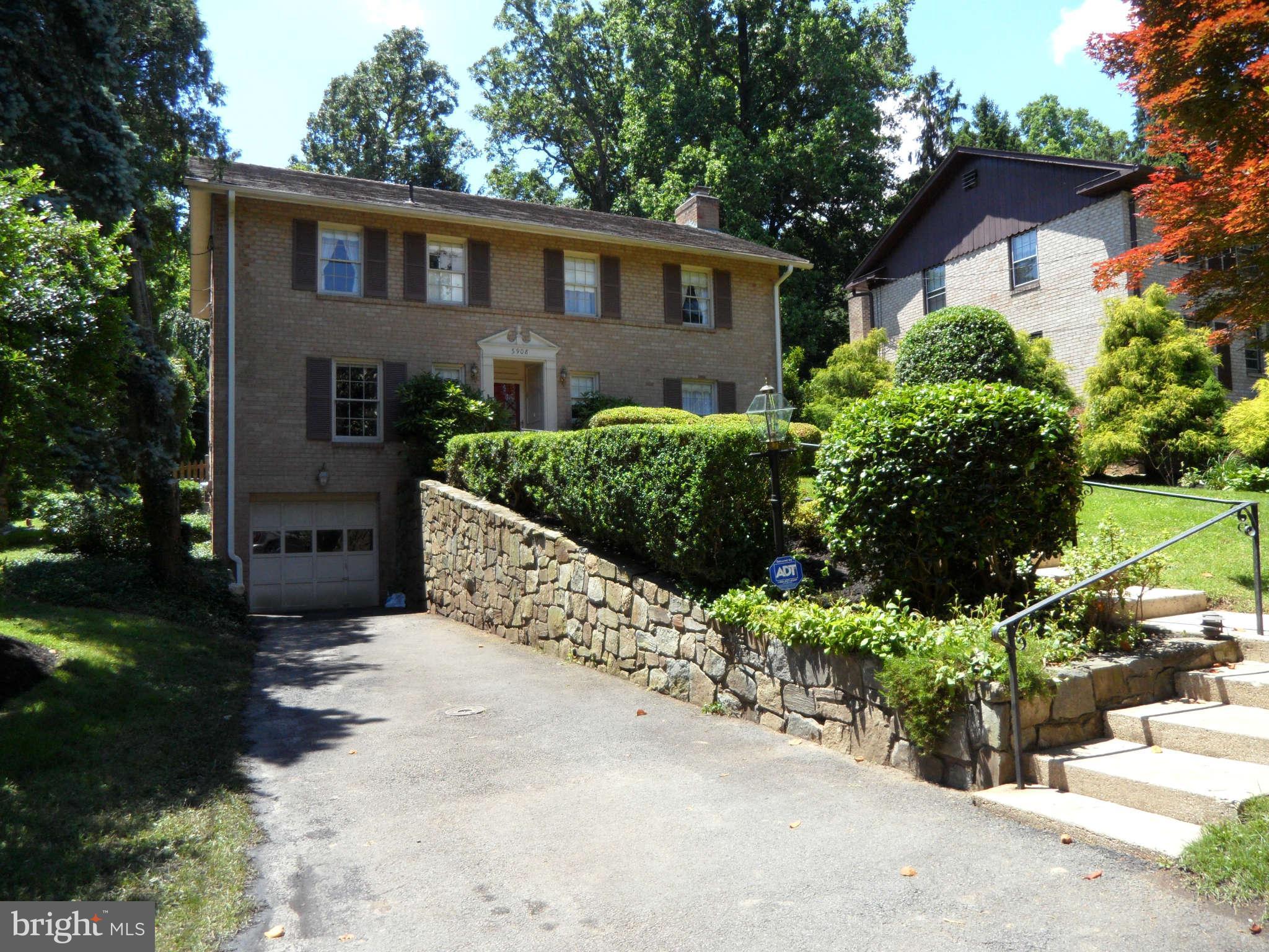 5908 Walhonding Road Bethesda, MD 20816 - Photo 2 of 26 a front view of a house with a yard and garage