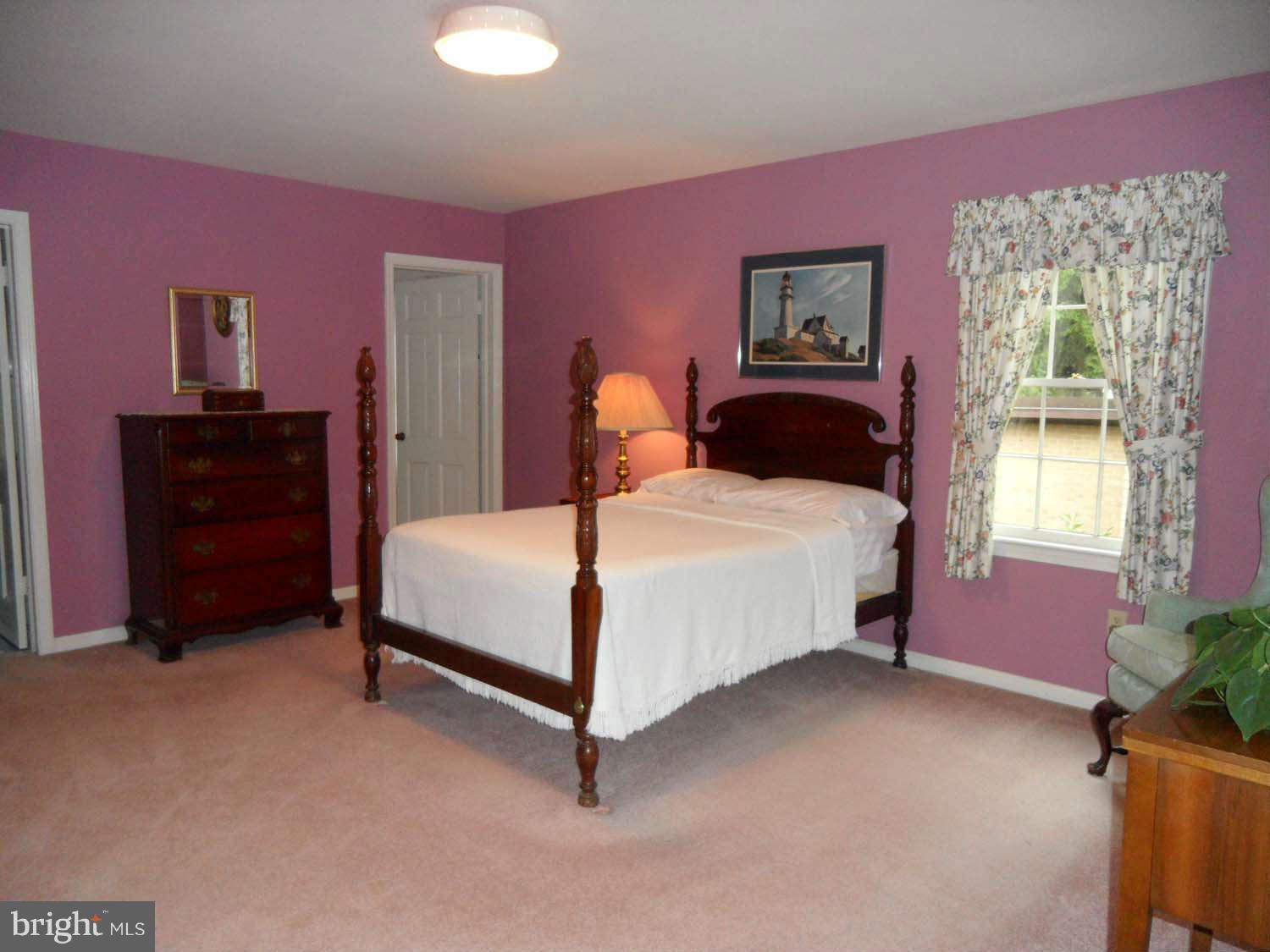 5908 Walhonding Road Bethesda, MD 20816 - Photo 13 of 26 a bedroom with a bed and a dresser next to a window